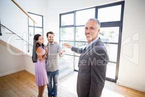 Real-estate agent giving keys to couple