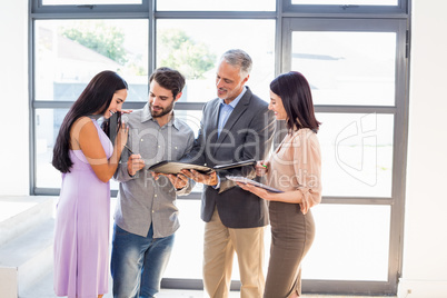 Real estate agent handing over agreement paper to couple