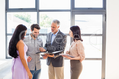 Real estate agent handing over agreement paper to couple