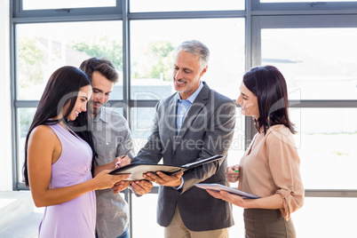 Real estate agent handing over agreement paper to couple