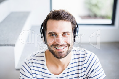 Portrait of happy man listening to music on headphone
