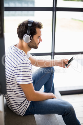 Man on steps listening to music on mobile phone