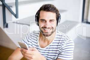 Portrait of happy man listening to music on mobile phone