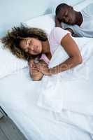 Young couple sleeping together on bed