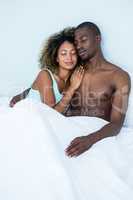 Young couple embracing each other on bed