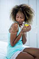 Young woman drinking a coffee on bed