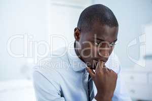 Thoughtful businessman sitting on bed