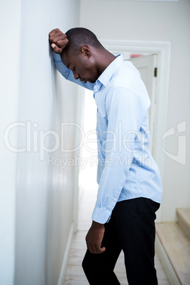 Tensed man leaning on wall