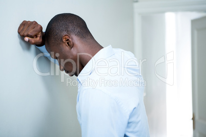 Tensed man leaning on wall