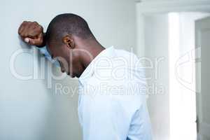 Tensed man leaning on wall