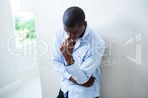 Tensed man leaning on wall