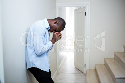 Tensed man leaning on wall