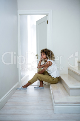 Tensed woman sitting on stairs