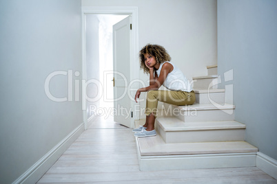 Tensed woman sitting on stairs