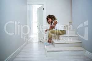 Tensed woman sitting on stairs