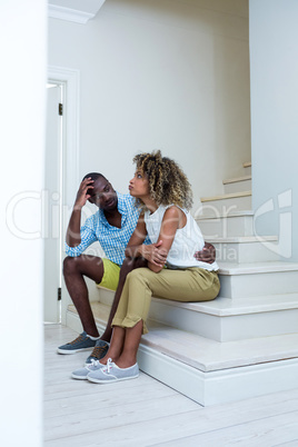 Young couple sitting on steps and talking
