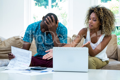 Worried young couple discussing on bills