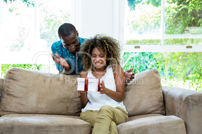 Man giving a surprise gift to her woman