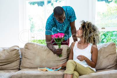 Young man offering a flower to woman