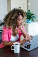 Young woman using laptop with coffee on table