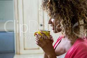 Young woman drinking a coffee on bed