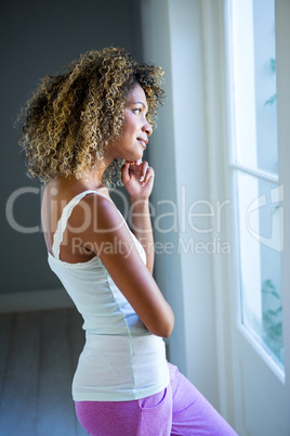 Thoughtful young woman looking out of the window