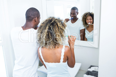 Young couple brushing their teeth at home