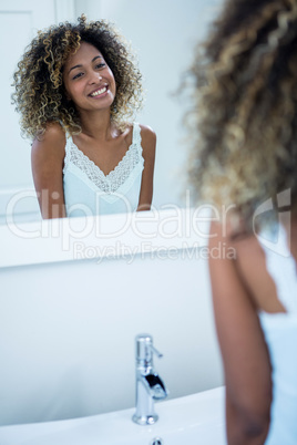 Woman looking in the mirror and smiling