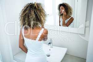 Young woman cleaning her face with sponge
