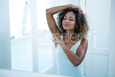 Young woman applying powder on her underarms