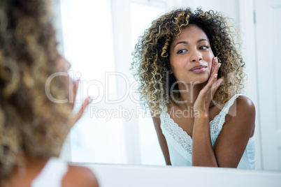 Woman checking her skin in bathroom