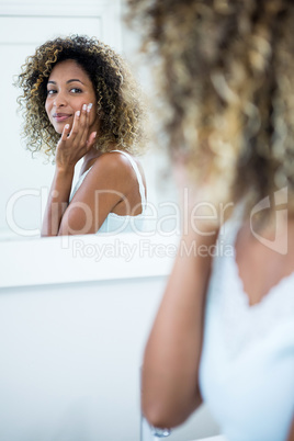 Young woman applying moisturizer