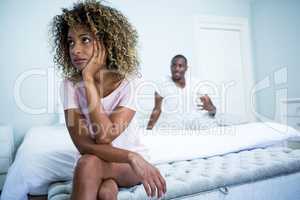 Upset couple ignoring each other after fight on bed