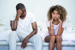 Upset couple ignoring each other after fight on bed