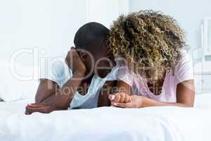 Young couple romancing face to face on bed