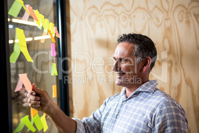 Man looking at sticky notes on window