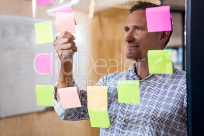 Man looking at sticky notes on window