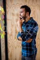 Thoughtful man looking at sticky notes on window