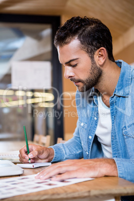 Man in office writing in a notepad