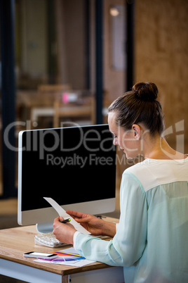 Woman reading a document in office