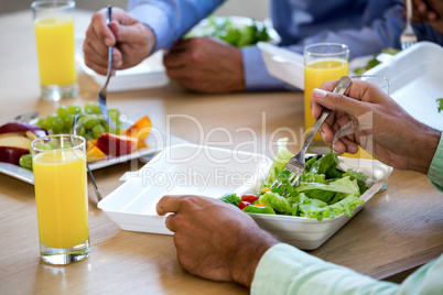 Colleagues having breakfast in office