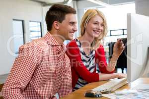 Colleagues working on computer and discussing