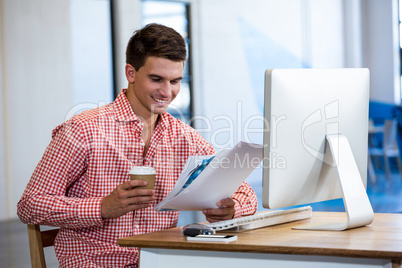 Man reading a document while having coffee