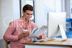 Man reading a document while having coffee