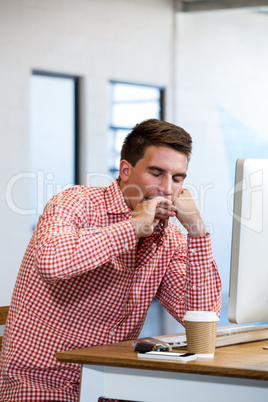 Man yawning at his desk