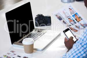 Man looking a chart with laptop and camera on desk