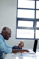 Man holding coffee cup and using digital tablet