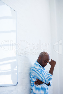 Upset man with eyes closed and finger on the forehead leaning ag