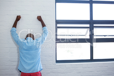 Upset man leaning against wall