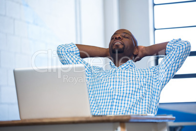 Man relaxing on chair with hands behind head